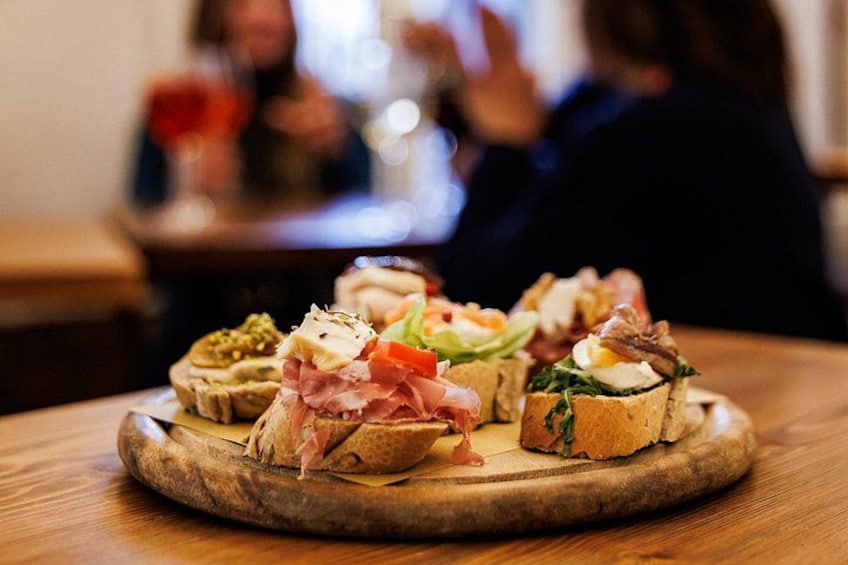 A wooden board with various food items, likely appetizers, on a table. 4