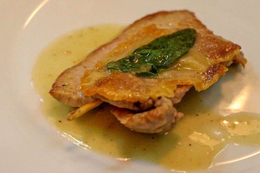 A dish with a golden-brown crust, a green leaf garnish, and a light sauce. 2