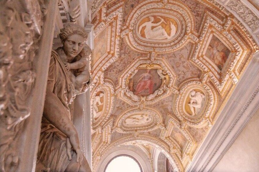 A detailed ceiling with intricate frescoes and sculptures. 1
