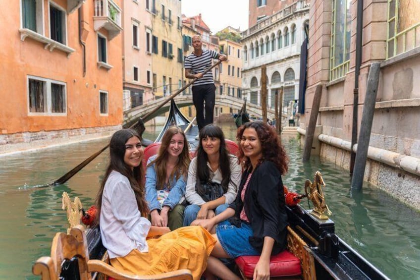 A gondola with passengers on a canal in Venice. 4