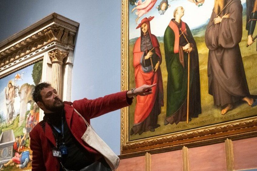 A person pointing at a painting with religious figures. 5