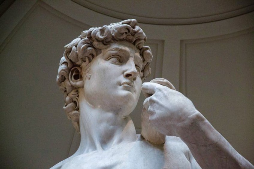 A marble statue with curly hair and a thoughtful pose. 1