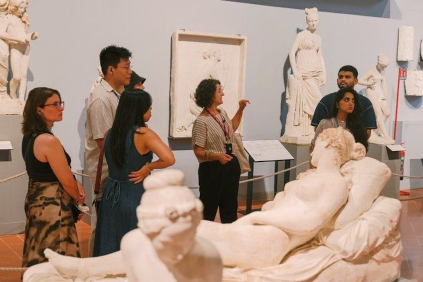 A museum with visitors observing sculptures. 4