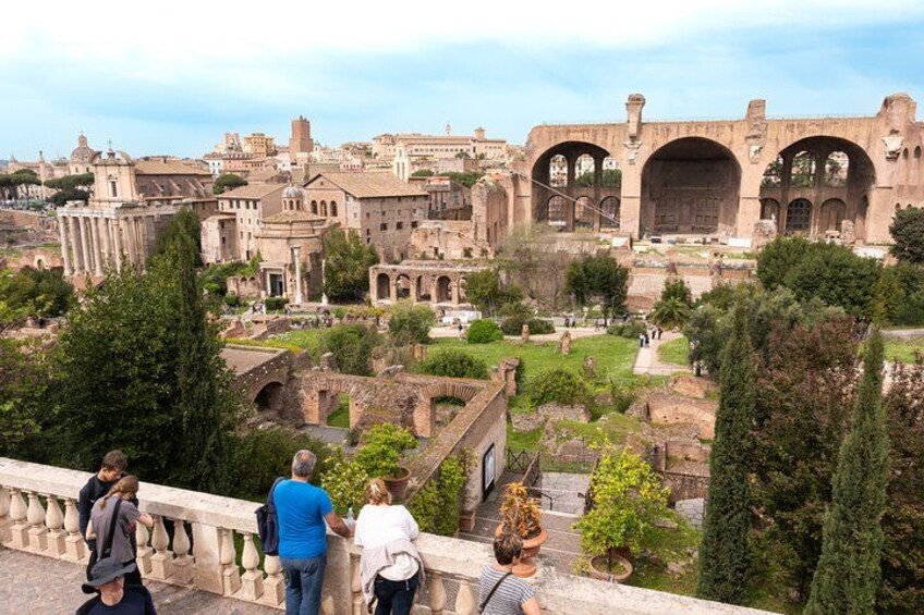 Ancient ruins with arches, a bridge, and a cityscape in the background. 4