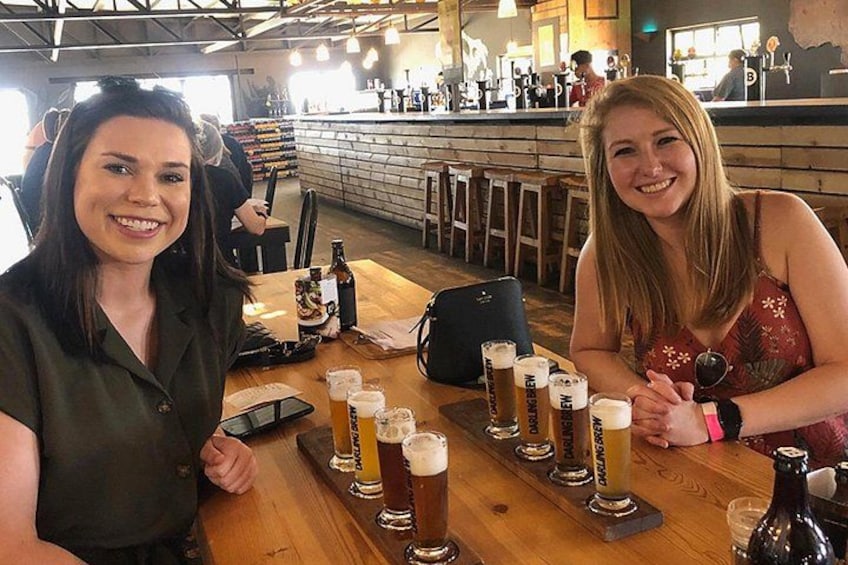 To kvinder sidder ved en bar med flere ølglas. 3