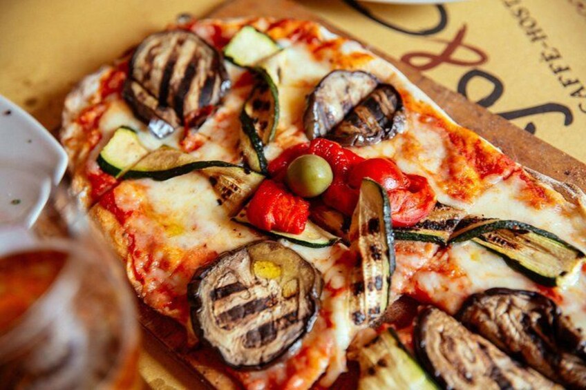 A pizza with grilled vegetables and cheese. 4