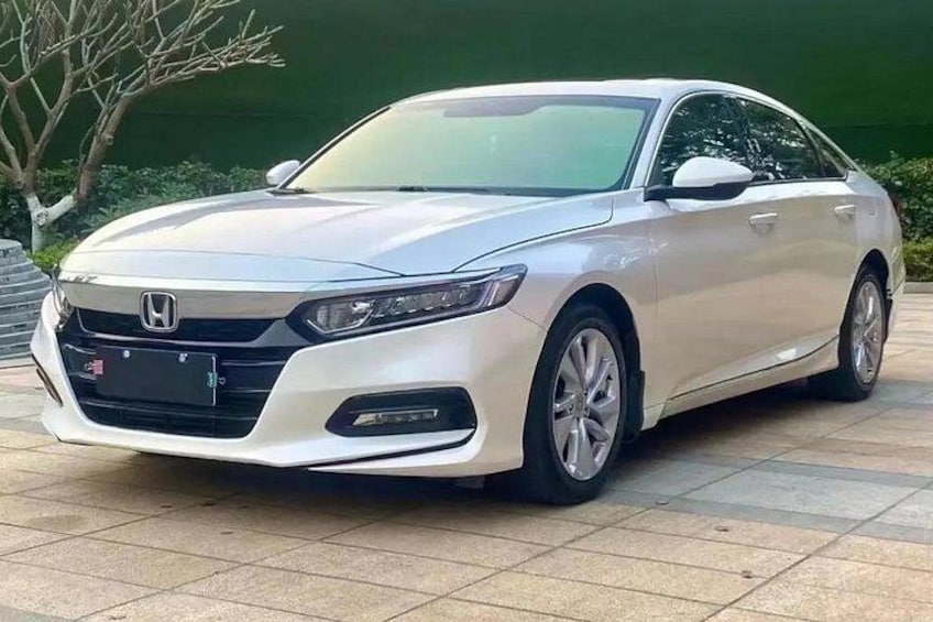 A white Honda sedan parked on a tiled surface. 2
