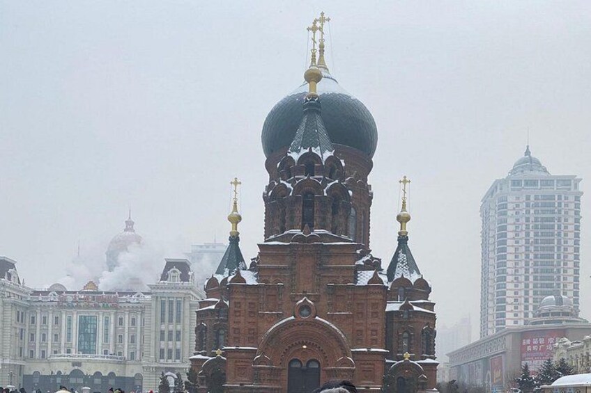 A historic church with ornate architecture and domes, surrounded by modern buildings. 5