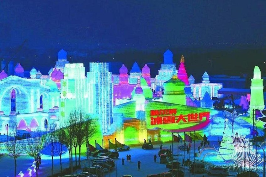 A nighttime cityscape with illuminated buildings and a large sign. 2