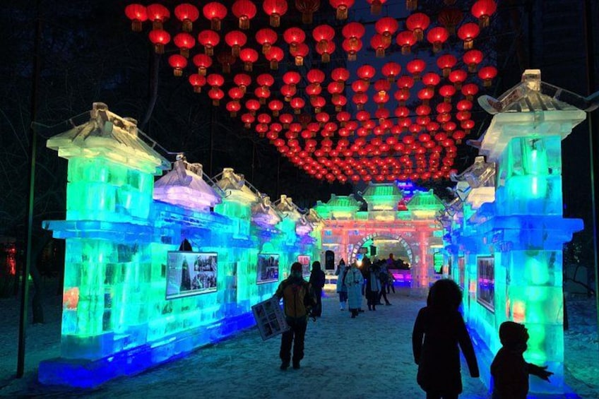An ice sculpture archway with illuminated red lanterns overhead. 1