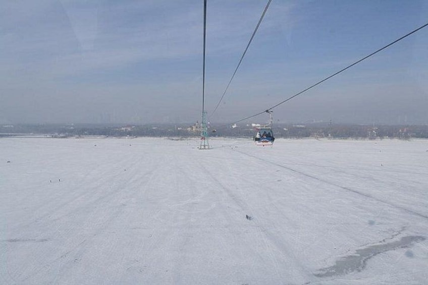 Schneebedeckte Landschaft mit Seilbahn und Sessellift in der Ferne. 3