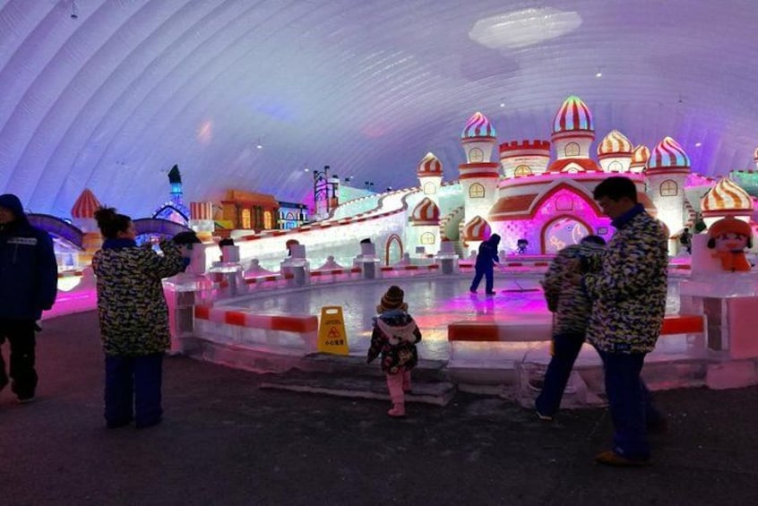 An indoor amusement park with illuminated structures and a domed ceiling. 3
