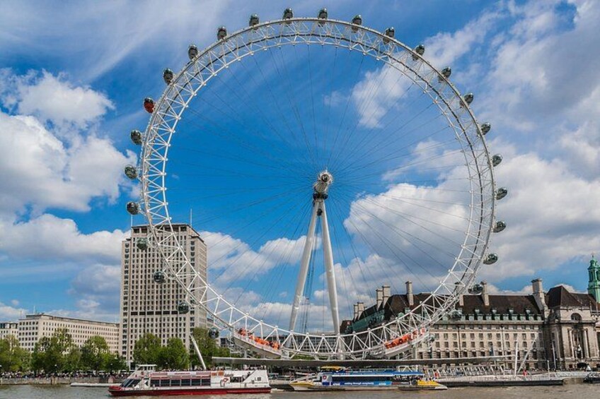 Une grande roue se dresse devant un ciel bleu azur et des nuages en arrière-plan. 3