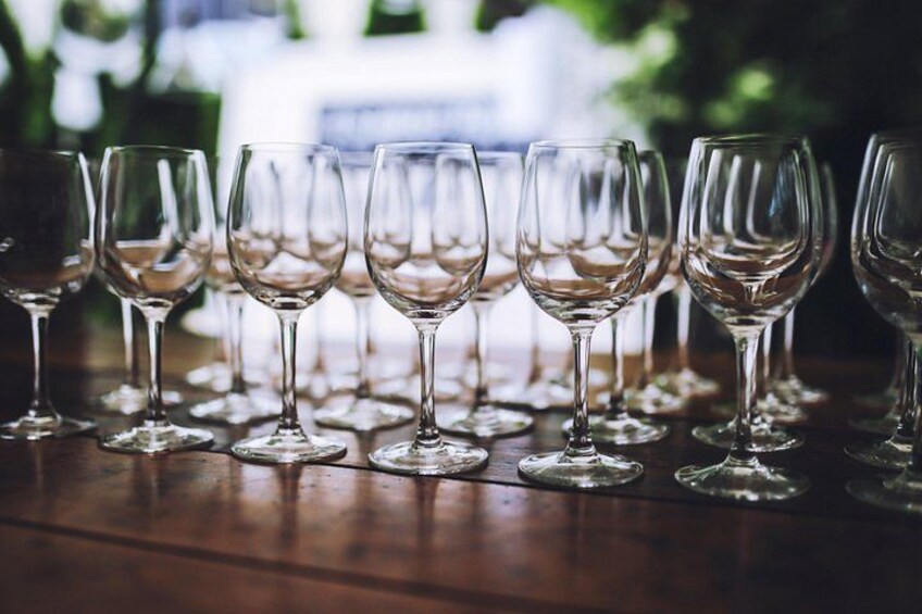 Una hilera de copas de vino vacías sobre una mesa de madera. 1