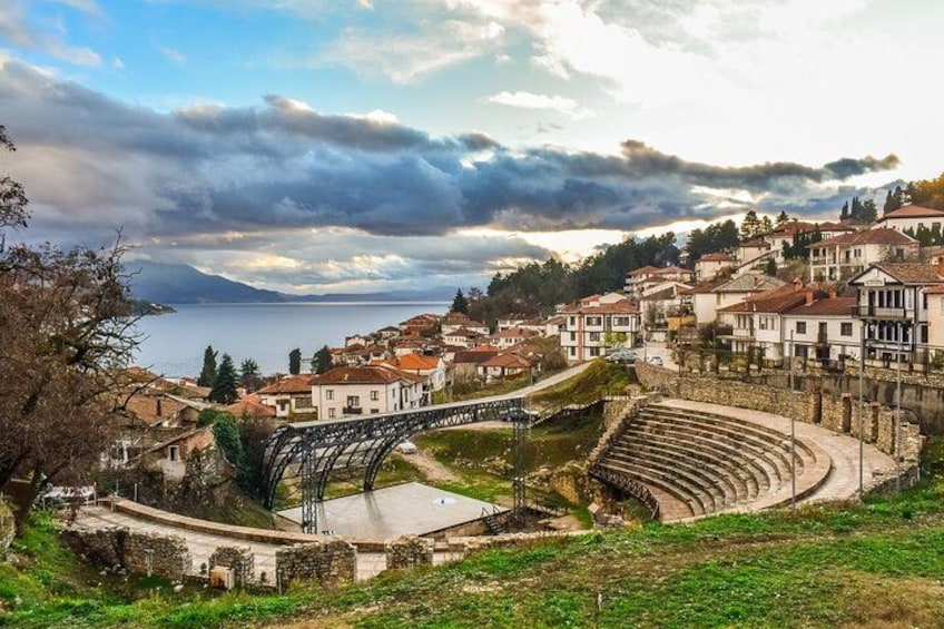 A coastal town with a historic amphitheater, a bridge, and a body of water. 2