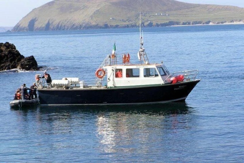 Un bote amarrado cerca de una costa rocosa con montañas al fondo. 4