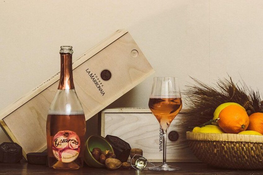Una botella de licor, un vaso de bebida y un cuenco de fruta sobre una mesa. 4