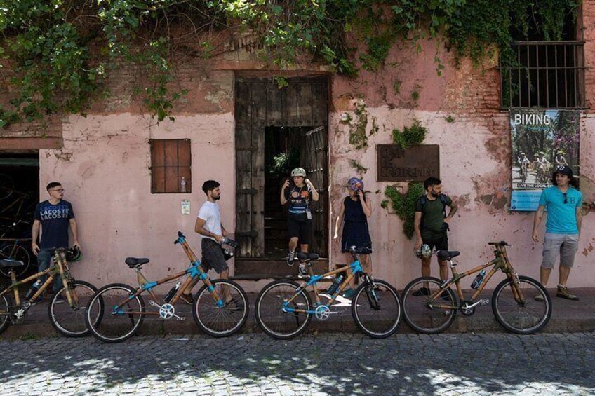 A group of people standing in front of a building with bicycles parked in front. 3