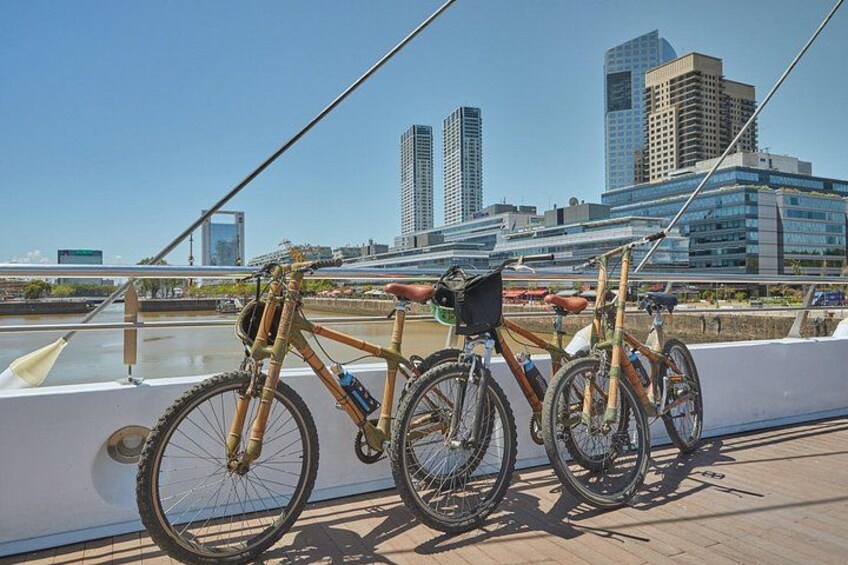 A bicycle parked on a dock with a city skyline in the background. 3