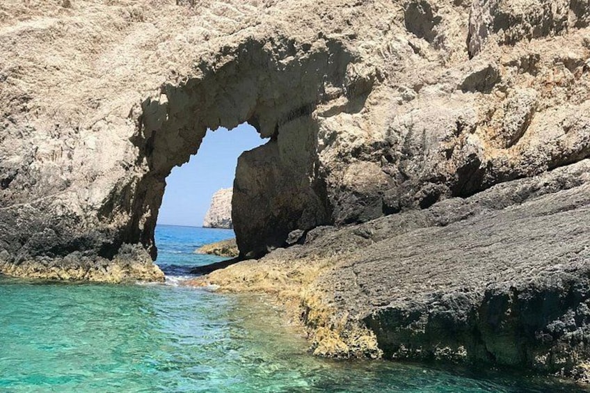Formación rocosa natural con un mar azul cristalino a través de un gran arco. 4