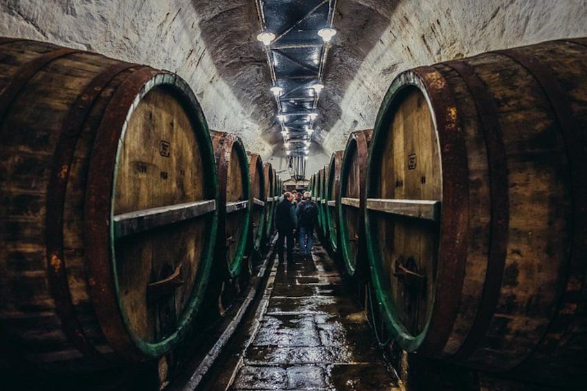 A tunnel with wooden barrels lining the walls. 1