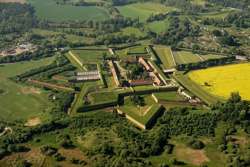 Luchtbeeld van een groot landgoed met uitgestrekte tuinen, een centraal gebouw en omliggende velden. 1