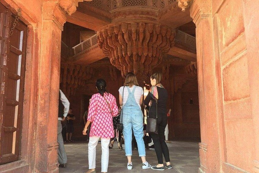Un groupe de personnes se trouve à l’intérieur d’un bâtiment historique à l’architecture riche et ornée. 1