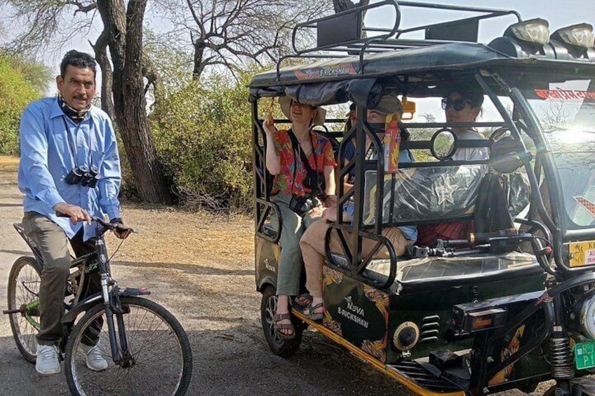 A man on a bicycle and a three-wheeled vehicle with passengers. 3