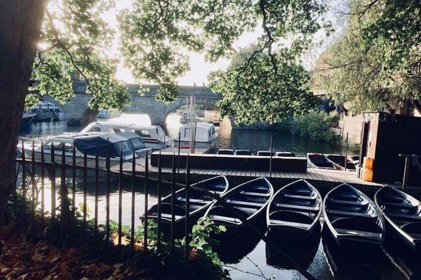 A riverside dock with several boats and a bridge in the background. 2
