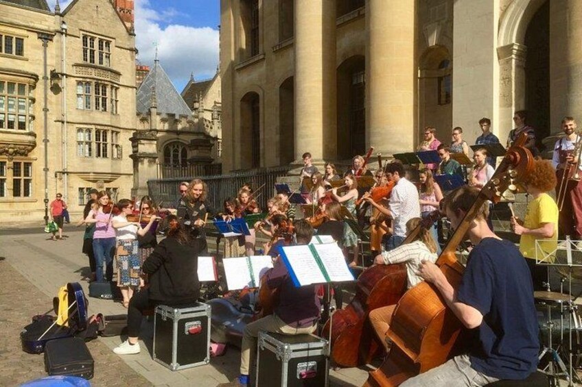A street performance with musicians playing string instruments. 4