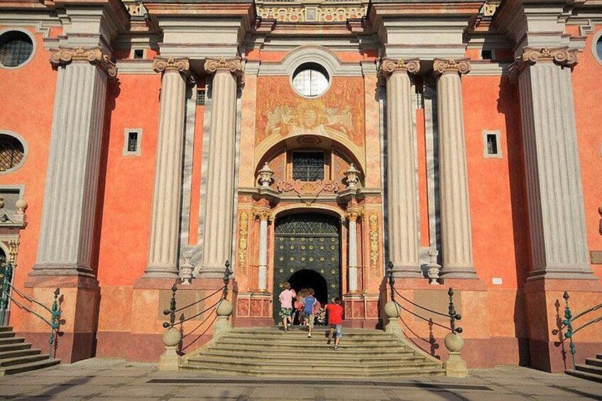 A grand entrance with a large archway, flanked by columns, leading to a building with a golden door. 5