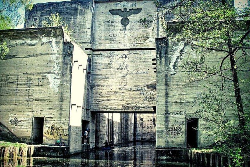 An old, weathered building with graffiti and a large emblem on the front. 3