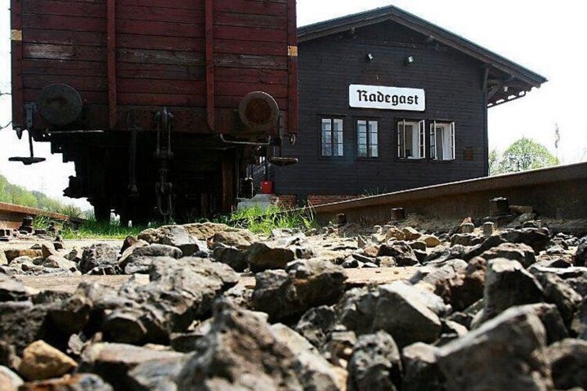 Un vagón de tren y un edificio con un cartel que dice 'Radegast'. 2