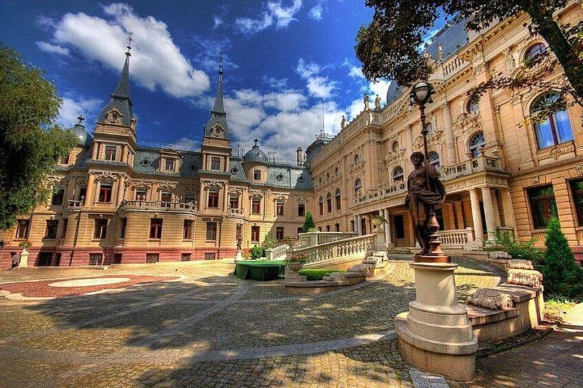 Ein historisches Gebäude mit aufwendiger Architektur, einer Statue und einem Brunnen. 1