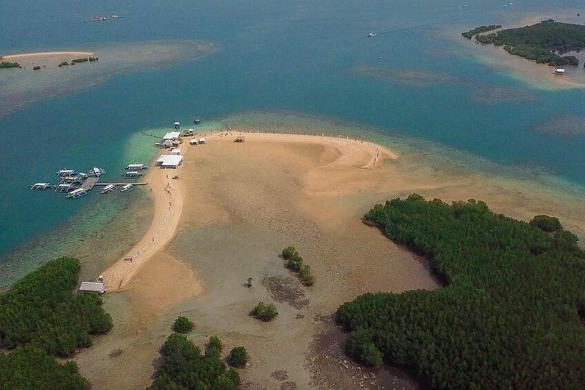 Oversigtsbillede af et kystområde med en sandstrand, både og en lille bebyggelse. 3