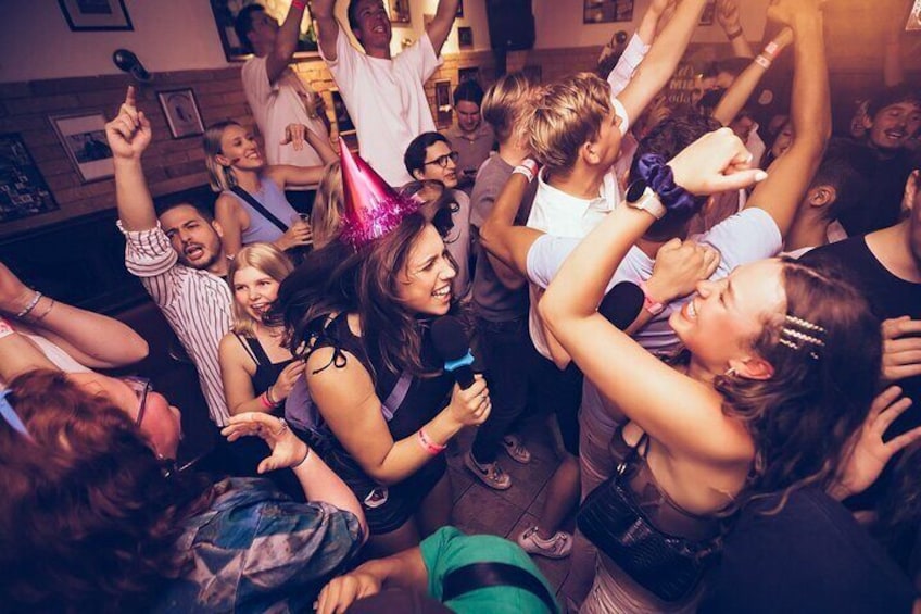 Een druk binnenfeest met dansende mensen en drankjes. 4