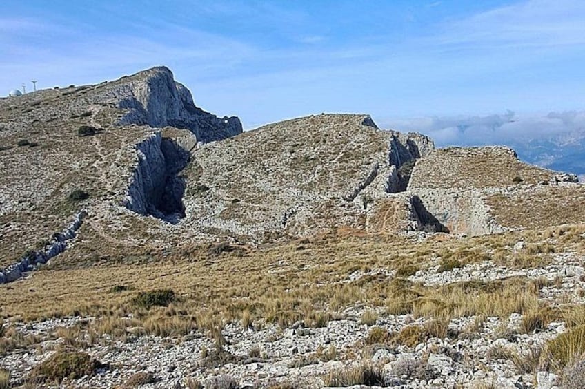 Een ruig berglandschap met rotsachtig terrein en schaarse begroeiing. 2