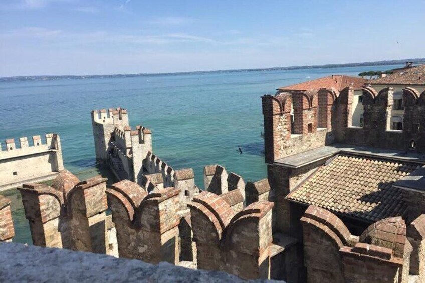 A coastal fortification with arched gateways and a tiled roof overlooking the sea. 3