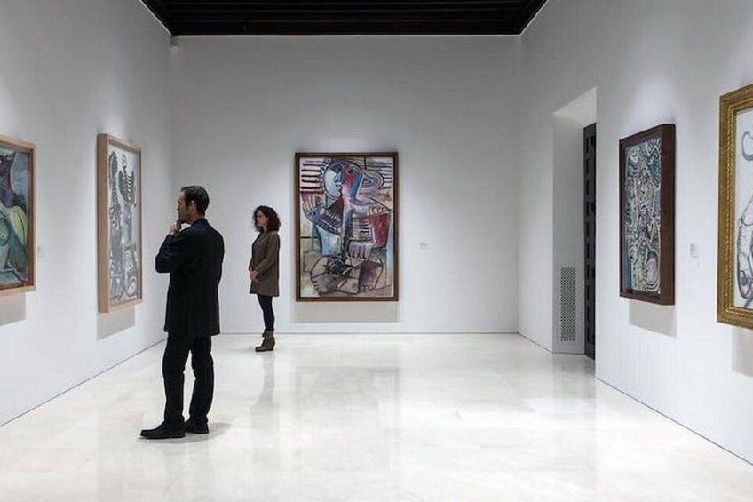 Una galería de arte con pinturas en las paredes y un piso pulido. 3
