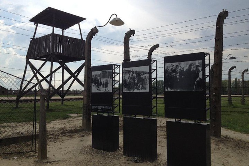A wooden watchtower, a fence, and informational panels. 1