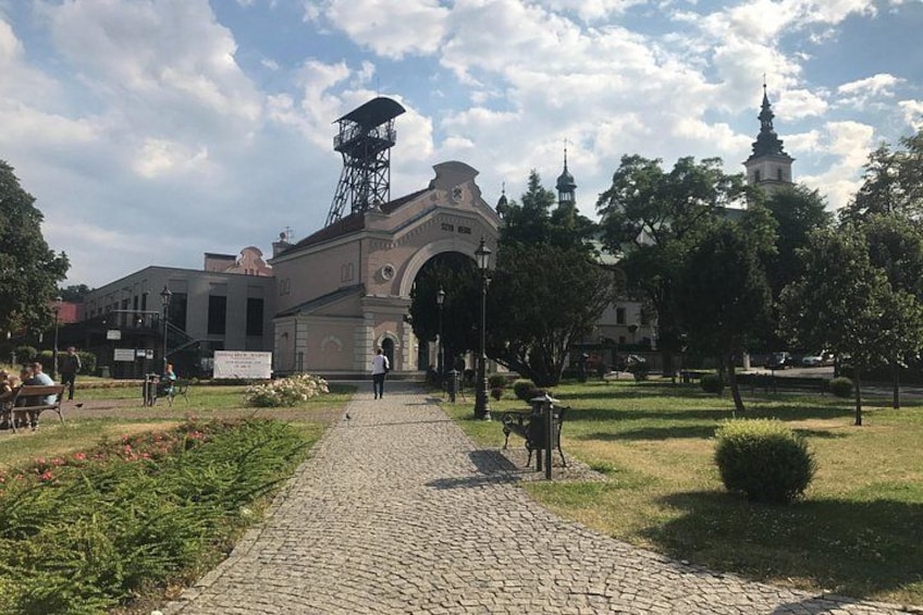A cobblestone pathway leading to a historical building with a tower, surrounded by greenery and a clear sky. 4