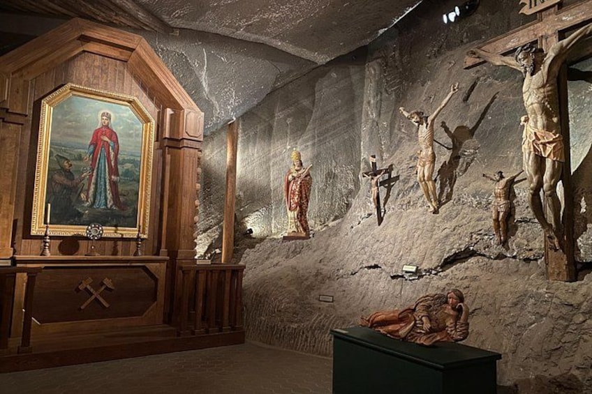 A religious interior with a wooden altar, a crucifixion scene, and a painting of a saint. 5