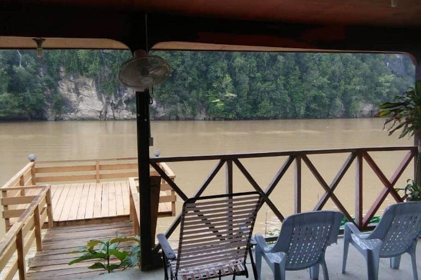A wooden deck with chairs overlooking a river. 4