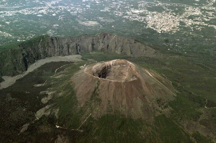 A large volcanic crater surrounded by green hills. 3