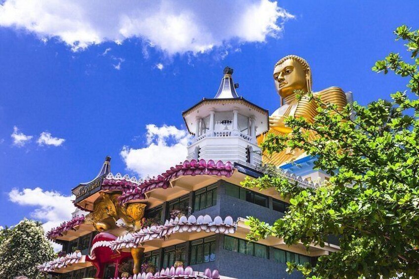 A large golden Buddha statue, a white pagoda, and a building with a traditional roof. 4