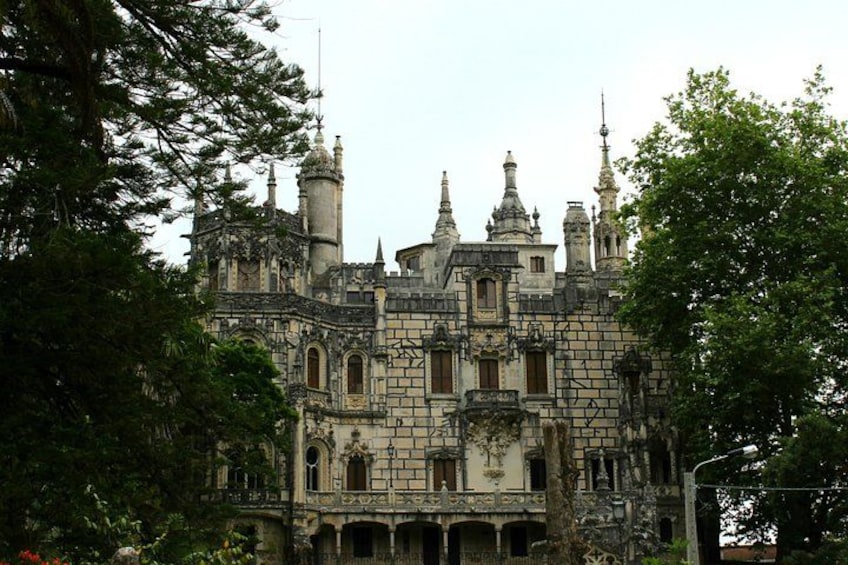 A large, ornate building with multiple towers and turrets, surrounded by lush greenery. 5