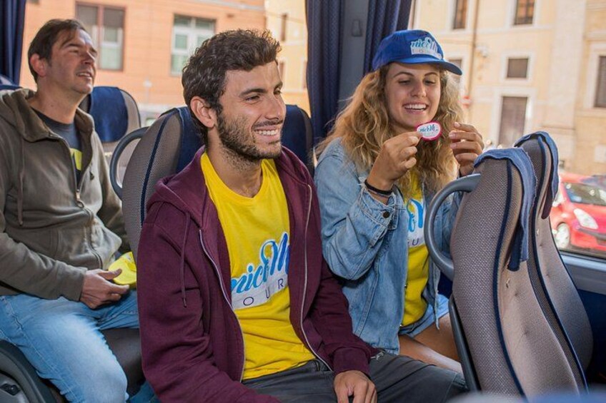Tres personas sentadas en un autobús, una de ellas sosteniendo un objeto rosa. 2