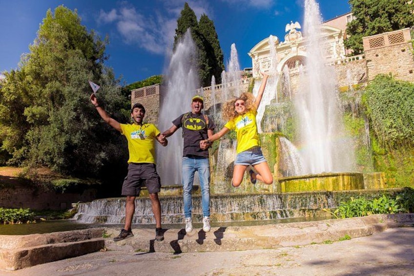 Three people jumping in front of a fountain with a building in the background. 3