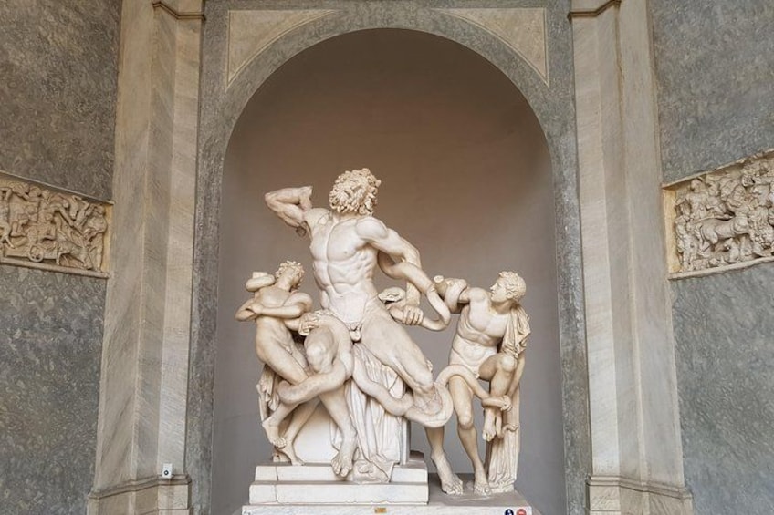 A marble sculpture of a muscular man in dynamic poses, set within an arched niche. 3