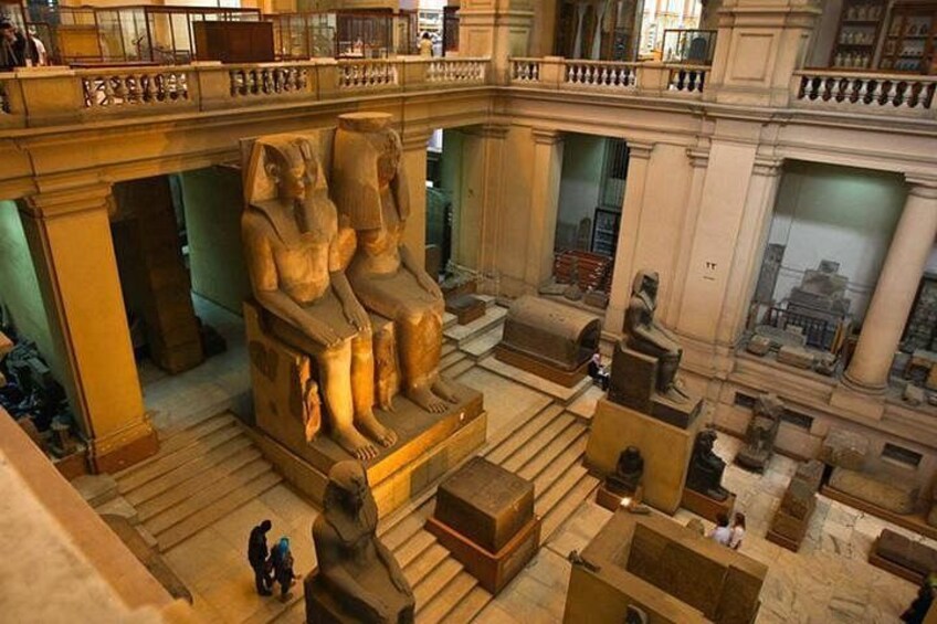 En stor, gammel egyptisk sarkofag med to figurer siddende, omgivet af stensøjler og en balkon. 5